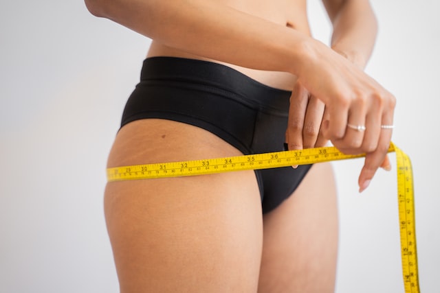 measuring tape around woman's stomach
